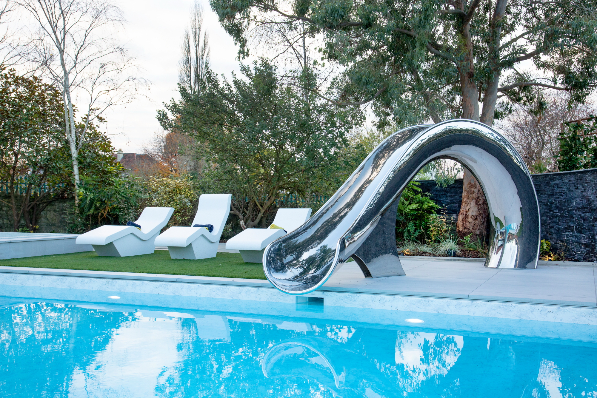 View across pool of Cyma slide and sun loungers